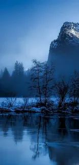 Serene mountain landscape with blue hues, mirrored in calm water.