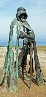 Bronze warrior statue with sword by the sea.