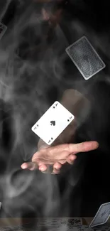 Hand levitating playing cards with smoky effect.