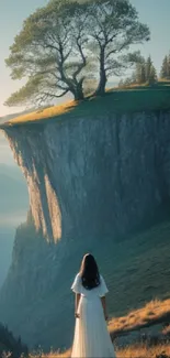 Woman in white dress gazing at a cliff with a tree under a serene sky.