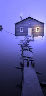 Misty lake house with purple hues and a wooden dock on a calm evening.