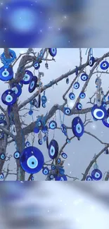 Blue evil eye charms hanging from branches against a serene sky.