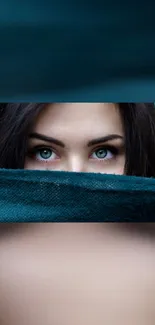 Mobile wallpaper of eyes peeking over teal fabric.