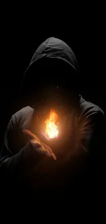 Mysterious hooded figure holding a glowing fireball in darkness.