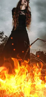 Witch standing in fire with orange flames and dark mystical backdrop.