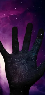 Silhouette of a hand against a dark purple galaxy background.