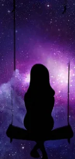 Silhouette on a swing with purple galaxy background.