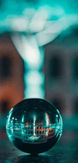 Turquoise glowing glass sphere with blurred city background.