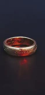 Gold ring with red glow on dark background.