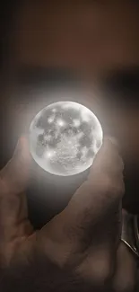 A hand holding a glowing moon orb in darkness, creating a mystical effect.