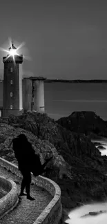 Lighthouse and couple silhouette in black and white at twilight.