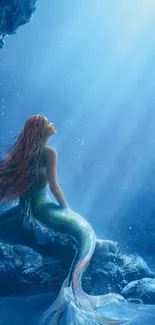 Mystical mermaid sitting in an oceanic blue underwater scene.