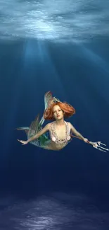 Enchanting mermaid swimming in deep ocean waters with sun rays above.