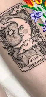 Moon tarot tattoo with colorful flowers.