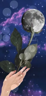 Hand holding leaves with moon in a dark mystical sky.