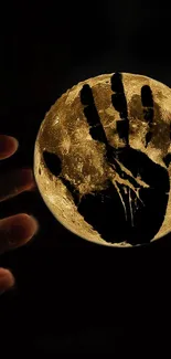 A hand shadow cast on a glowing moon, creating a mysterious and mystical wallpaper.