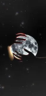 Hands embracing the moon against a dark background, creating a mystical effect.