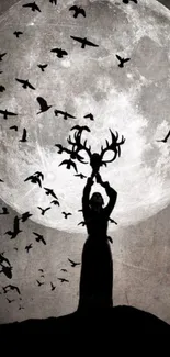 Silhouette holding antlers under full moon with birds flying.