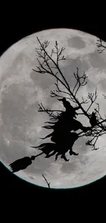 Silhouetted witch flying across a full moon in a dark night sky.