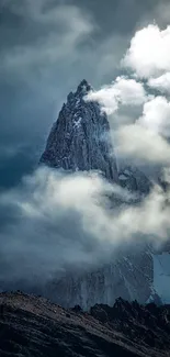 A majestic mountain peak enveloped by clouds, creating a mystical landscape.