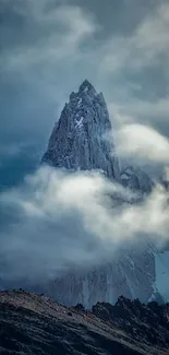 Majestic mountain peak surrounded by clouds, creating a mystical atmosphere.