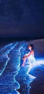 Woman sitting on a glowing beach at night under a starry sky.