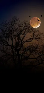 Silhouetted tree with a glowing moon and bats at night.