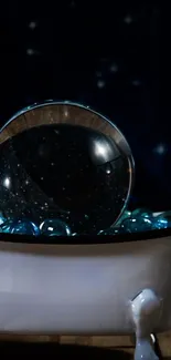 Crystal orb in a bowl of blue marbles with a dark starry background.