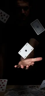 Hand throwing playing cards in dark setting, magic theme.