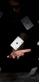 Mystical image of floating playing cards around an extended hand in dramatic lighting.