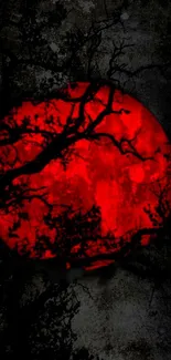 Mystical red moon with dark tree silhouettes on a mobile wallpaper.