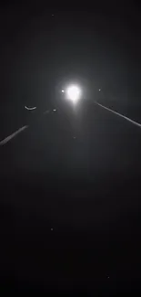 Mysterious night road with bright illumination and dark surroundings.