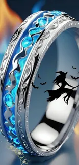 Silver ring with blue enamel and witch silhouette against fiery background.