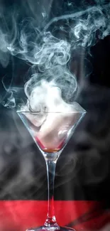 Smoke swirls in a martini glass on a red surface.