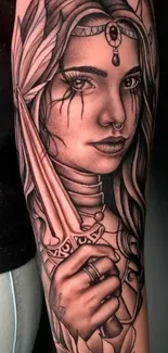 Grayscale tattoo of a mystical warrior woman on arm.