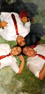 Three friends in white and red lying on green grass.