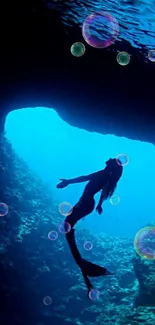 Silhouette of a mermaid swimming in an underwater cave.