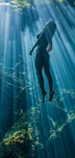 Silhouetted diver under water with sunbeams streaming through in a mystical scene.