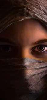 Close-up portrait of eyes veiled in fabric, creating a mystical and captivating look.