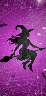 Silhouette of witch flying over webbed purple sky.