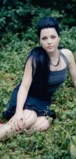 Woman in a dark dress surrounded by lush green plants outdoors.