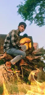 Young man sitting on a wooden log with blue sky.