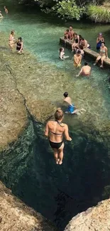 People enjoying a serene natural pool with clear blue water.