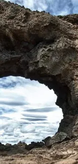 Stunning natural rock arch with sky backdrop.