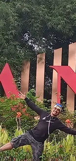 Joyful person posing in lush garden with red signage.