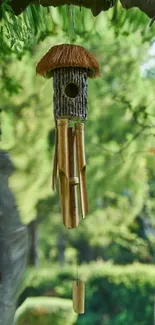 Rustic wind chime hanging amid lush green foliage.