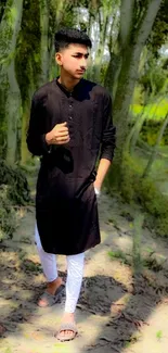 Man in black kurta walking in a lush green forest