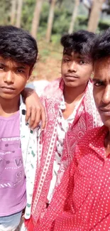 Three friends posing outdoors with a nature backdrop.