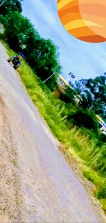 Dirt path through greenery with surreal orange sun.