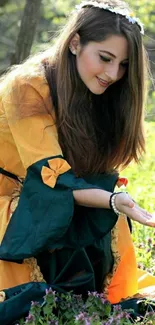 Girl in princess dress sitting in a meadow surrounded by vibrant flowers.